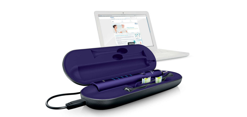 a toothbrush in a case next to a laptop