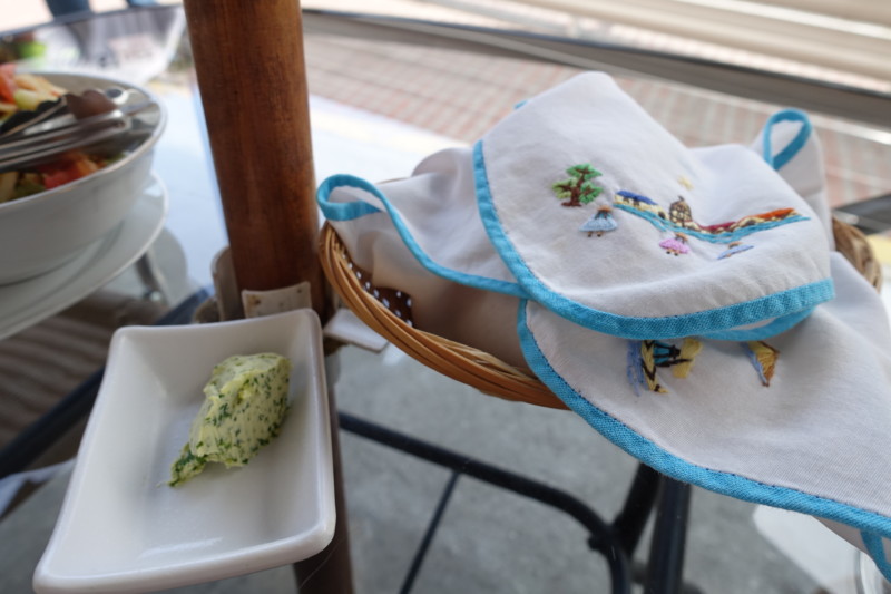 a basket with baby bibs and a plate of butter