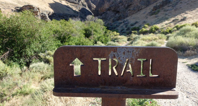 a sign with a trail in the background