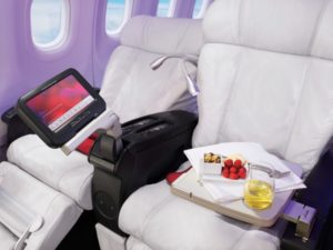 a tray of fruit and a tray of food on a tray in a plane