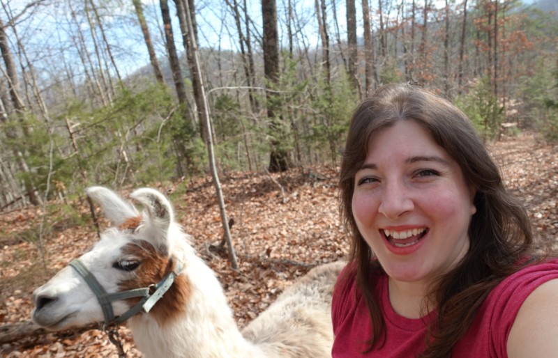 a woman taking a selfie with a llama