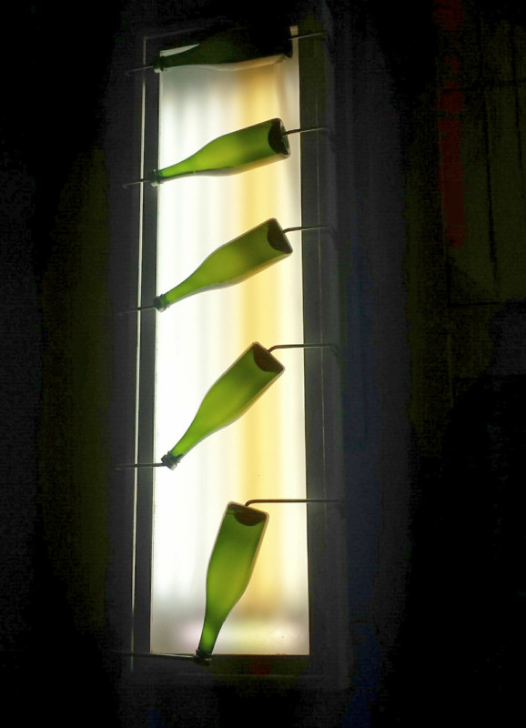 a group of green bottles with straws in a window