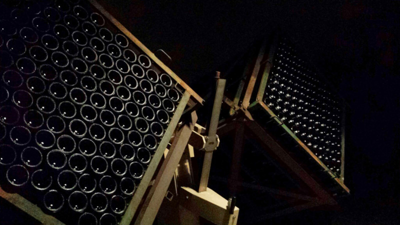a group of wine bottles stacked on a metal stand