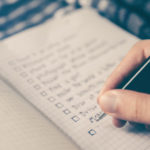 a person writing on a checklist