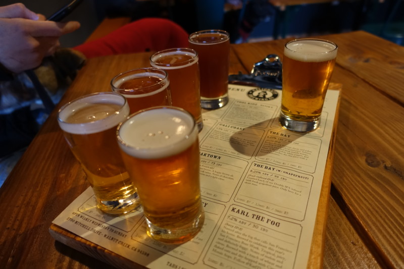a group of glasses of beer on a wooden table