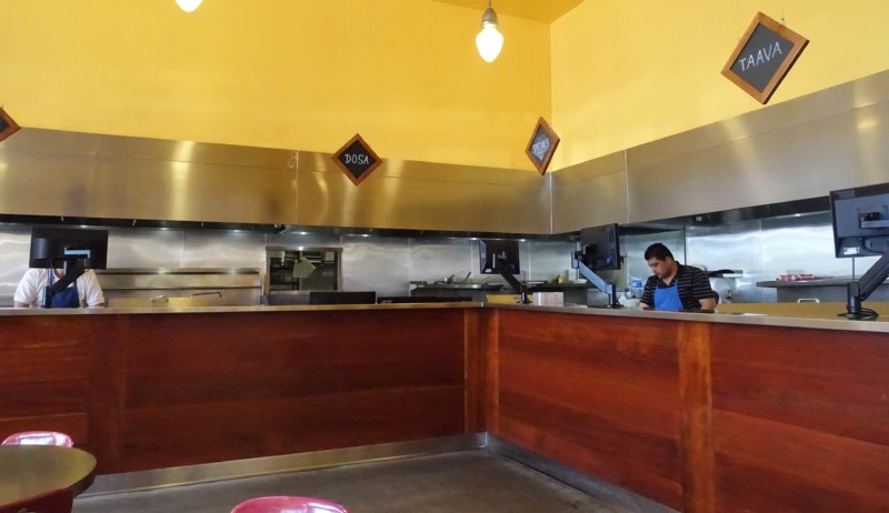 a man standing behind a counter in a restaurant