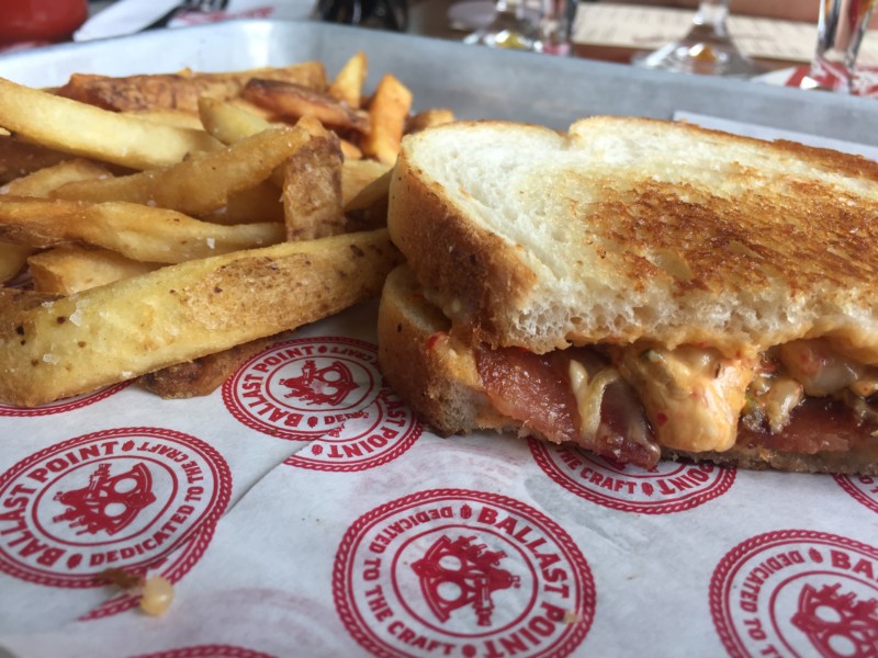a grilled cheese sandwich and fries on a paper wrapper