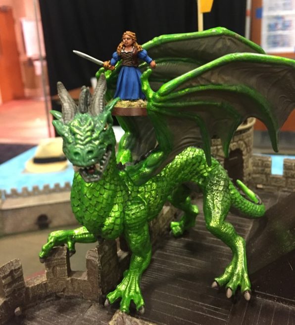 a toy figurine of a woman riding a dragon