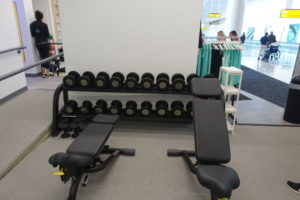 a gym with weights and a rack of weights