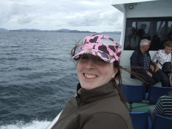 a woman wearing a pink hat on a boat