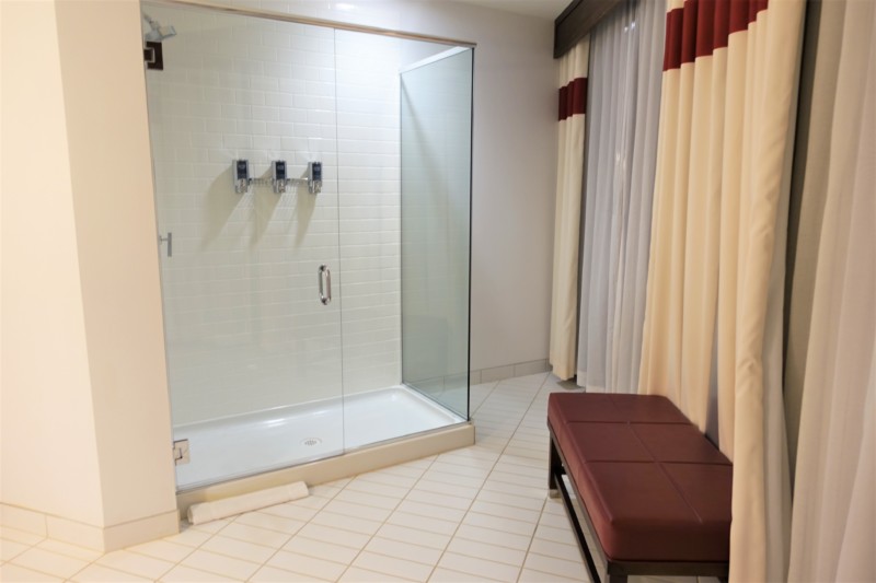 a shower with a bench and shower curtain