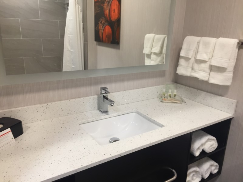 a bathroom sink with a mirror and towels