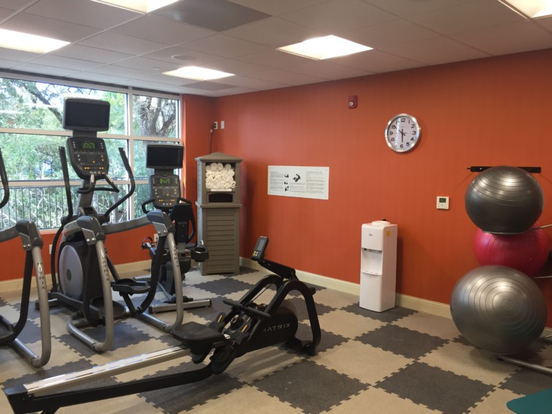 a room with exercise equipment and a clock