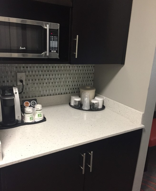 a kitchen counter with a microwave and coffee maker