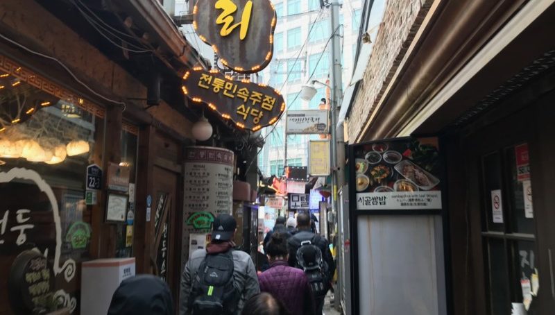 a group of people walking in a narrow alley