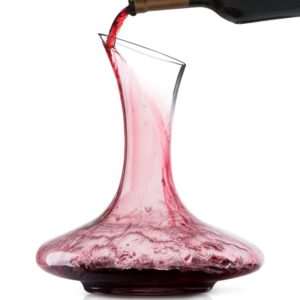 a red wine being poured into a decanter
