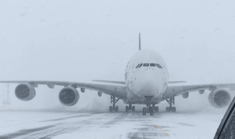 a plane on a runway in the snow