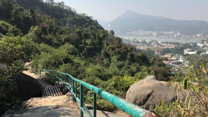 a green railing on a mountain