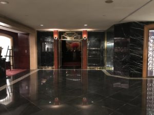 a black marble floor with a red vase in front of it