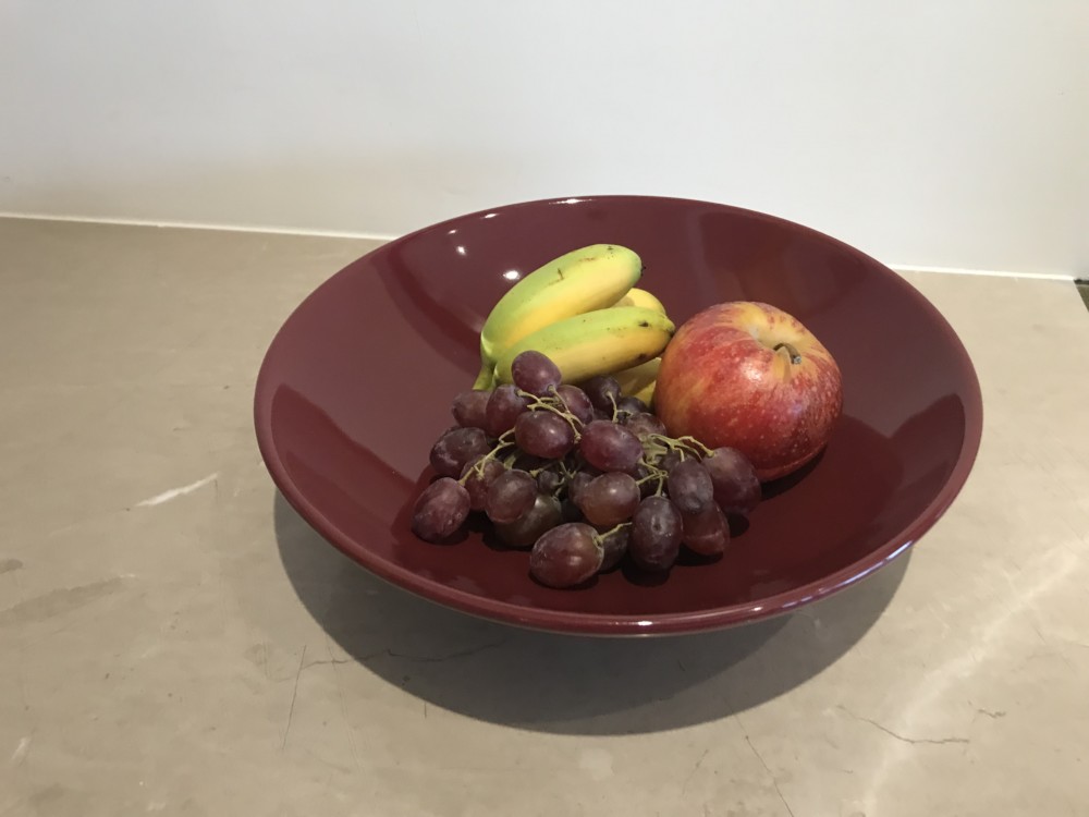 a bowl of fruit on a marble surface