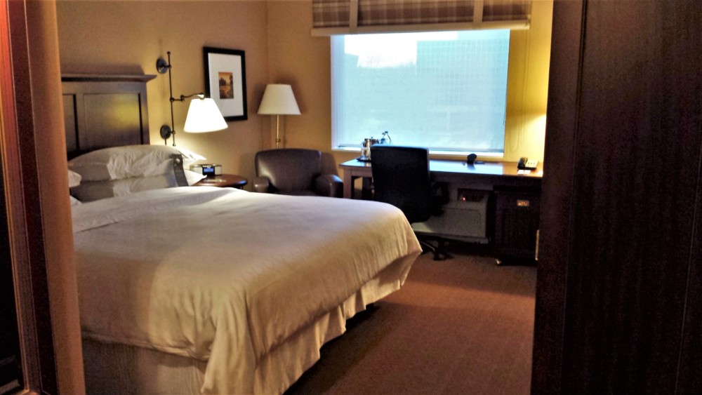 a hotel room with a bed and a desk