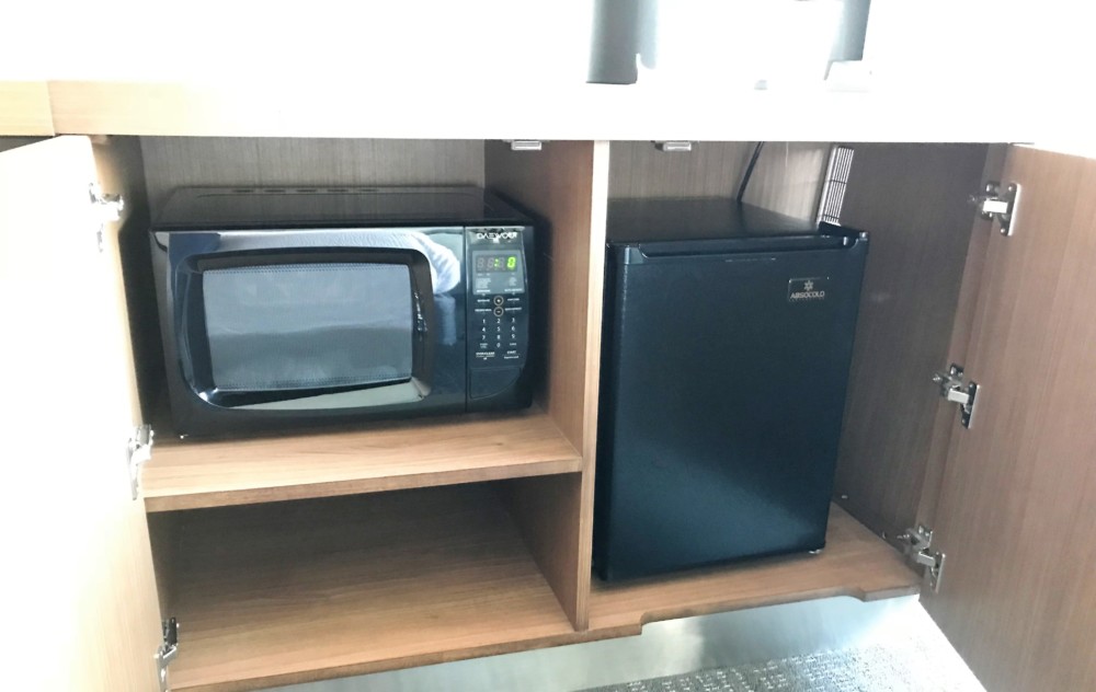 a microwave and a small refrigerator on a shelf