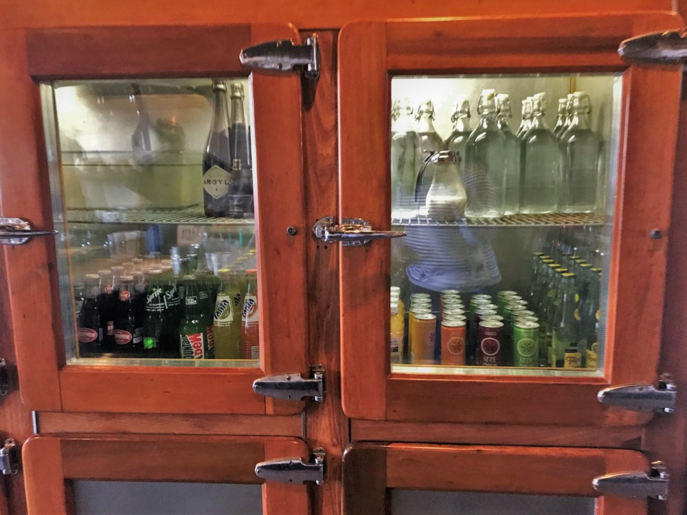 a glass cabinet with bottles and cans